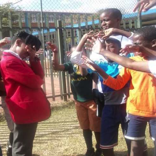 An upset girl standing in front of a soccer coach and some boys telling her to go away.