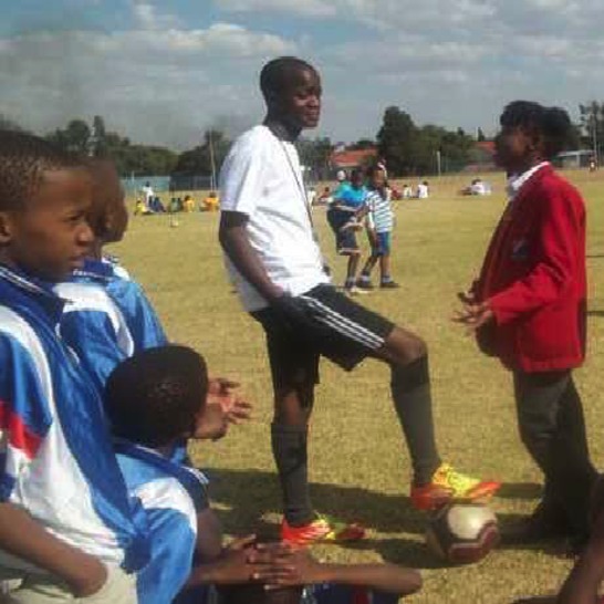 A girl talking with a soccer coach.